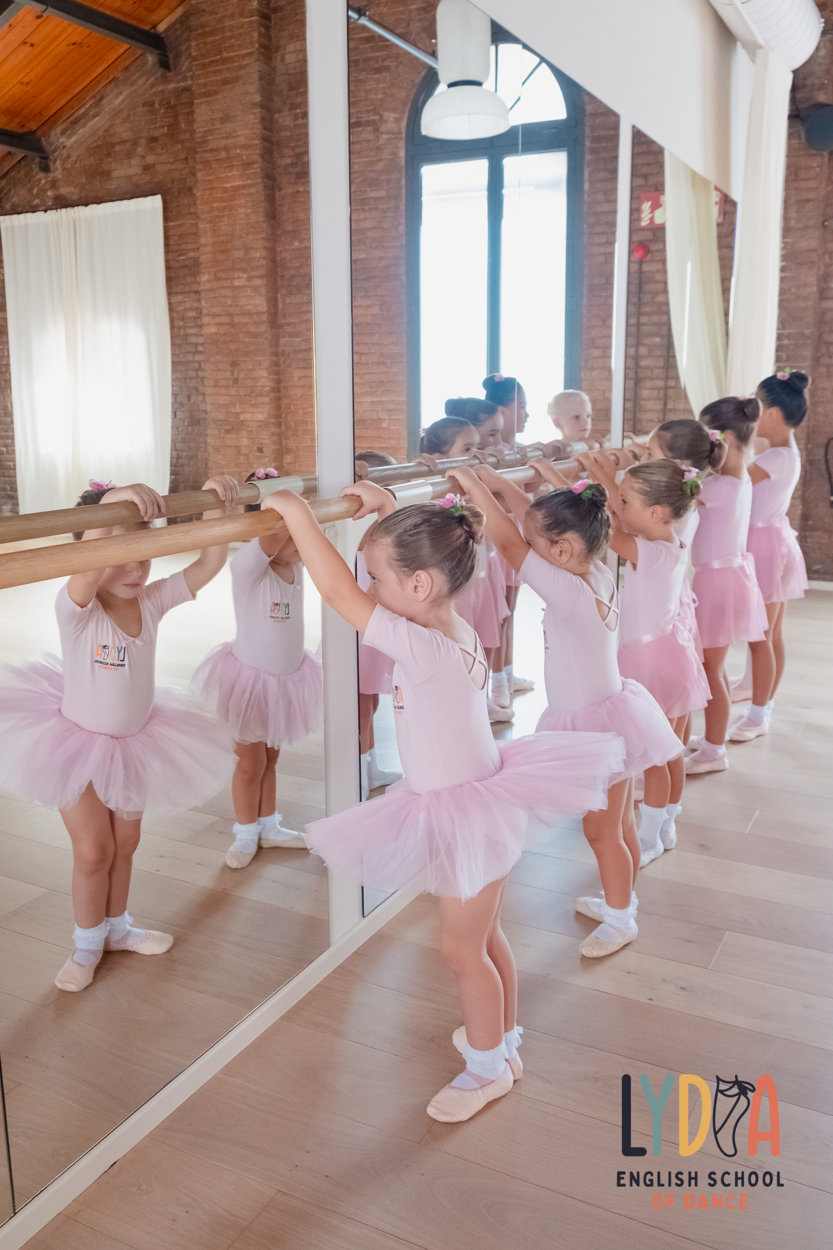 Young ballet students practising at the studio barre